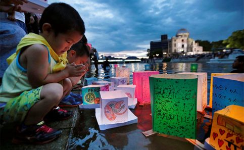 Niños rezan después de lanzar linternas de papel en el rió Moyotasu. Foto: Reuters