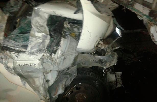EL CUERPO de la víctima quedó prensado entre los restos del auto que se impactó por alcance contra un camión.