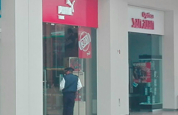UN VIGILANTE observa al interior de la joyería “Puma Time” ubicada en Plaza Galería, que fue asaltada ayer por dos jóvenes que tras el ilícito huyeron.