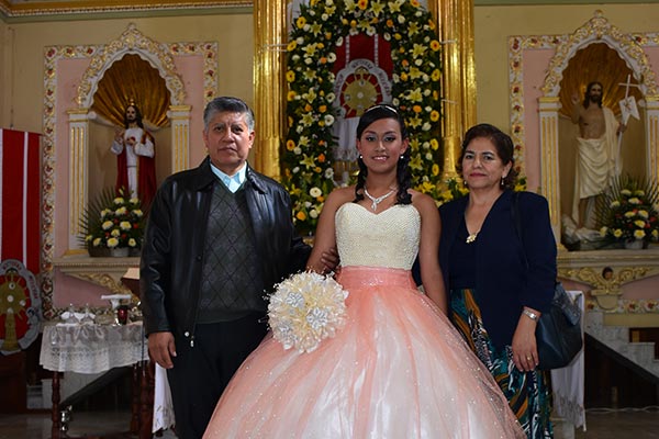 La quinceañera acompañada de sus padrinos