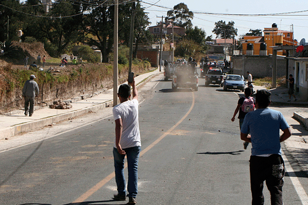 Después de cinco minutos de zafarrancho, la PEA emprendió la retirada al lanzar gas lacrimógeno para dispersar a los huilopenses. / Héctor LORENZO