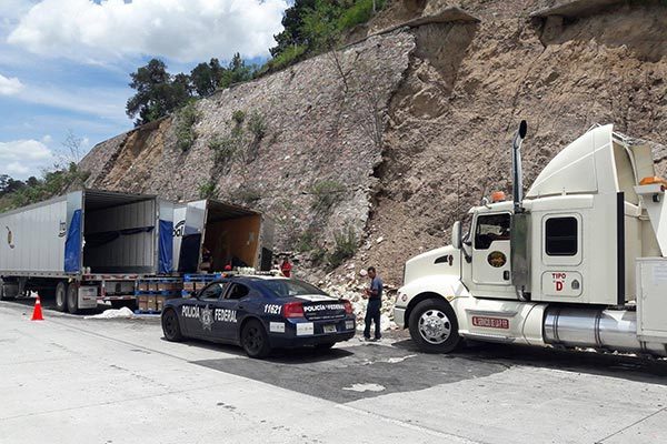 Un tractocamión que transportaba mayonesa se volcó al impactarse con desechos del talud de concreto, quedando los botes de este producto regados sobre las piedras. / Tomás BAÑOS