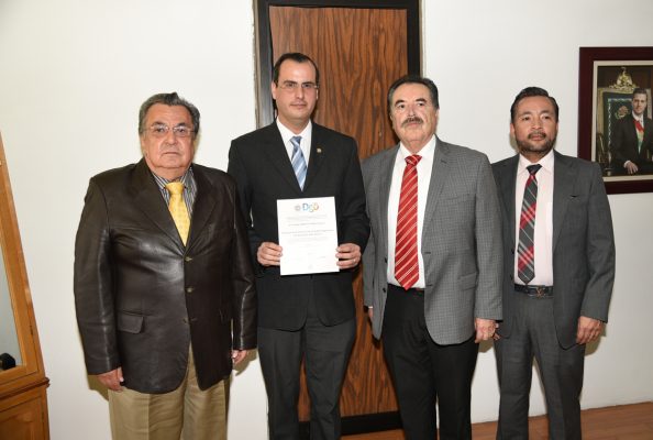 Con nombramiento en mano se observa en Jorge Calero, quien es el nuevo director de la División de Estudios Superiores de la 18 de Marzo.